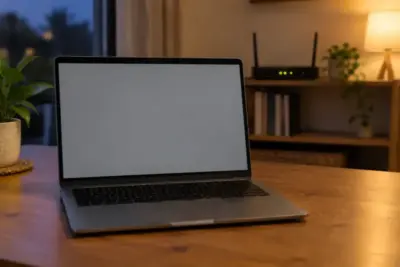 An open laptop with a blank screen on a table, a home router visible on a shelf behind it